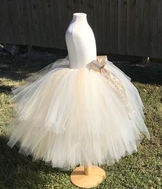 This listing includes an ivory and champagne/beige tutu with a gold glitter bow. This listing if for waist sizes up to 34 1/2" can be made larger if interested contact me for a special listing. Other colors also available. The ivory and champagne/beige tutu pictured is the 19-24” length range with a longest layer of 20” and top layer of 17”. Tutu can be all one length or the dual lengths. **please just note the length you would like or lengths you would like upon checkout***Thank you for shoppin Gold Ruffled Tutu Dress For Wedding, Gold Ruffled Tutu Dress For Pageants, Cream Tulle Tutu Dress For Pageants, Cream Tulle Tutu Dress For Pageant, Gold Ruffled Tutu Dress For Pageant, Cream Tutu Dress For Pageant, Fitted Gold Tulle Tutu Dress, Gold Tulle Tutu Dress With Ruffles, Gold Tulle Tutu Dress For Pageants