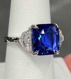 a ring with a blue stone surrounded by three diamonds