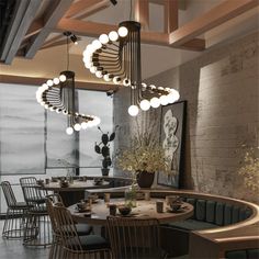 an elegant dining room with round tables and modern lighting fixtures hanging from the rafters