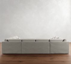 a couch sitting on top of a hard wood floor next to a white wall in an empty room