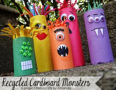 four different colored paper tubes with monster faces on them