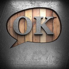 the word ok spelled in metal letters on top of wooden planks with a speech bubble