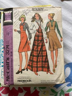 an old sewing book with two women's dresses on it