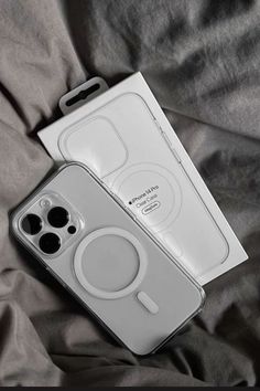 an iphone case sitting on top of a bed next to a box with two buttons