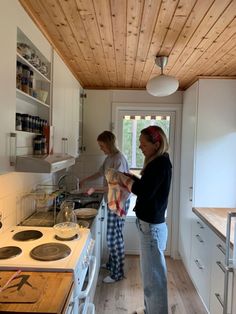 two women standing in a kitchen preparing food