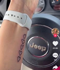 a wrist tattoo with the word jeep on it and an image of a car steering wheel