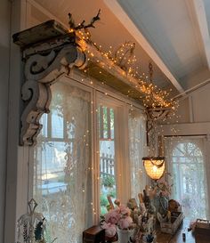 a window with lights hanging from it's side and flowers in vases on the windowsill