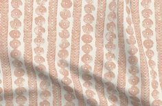 an orange and white patterned fabric with small leaves on the side, as well as a shadow