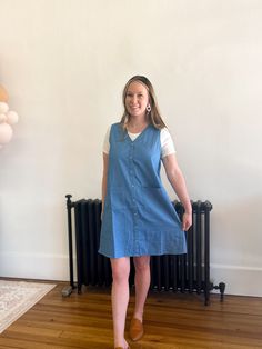 Get ready to rock the denim trend with our Denim Daze Shift Dress! This lightweight, sleeveless dress is perfect for spring and can be easily layered for a versatile look. The button up design adds a touch of functionality to this stylish piece. Embrace the denim mania with our must-have dress! Summer Denim Vest With Buttons For Workwear, Knee-length Chambray Dress With Pockets, Casual Cotton Sleeveless Dress, Casual Mini-length Denim Vest For Spring, Casual Sleeveless Dress With Pockets For Daywear, Casual Sleeveless Dress With Pockets, Casual Sleeveless Knee-length Dress For Spring, Spring Workwear Denim Blue Mini Dress, Casual Button-up Chambray Dress