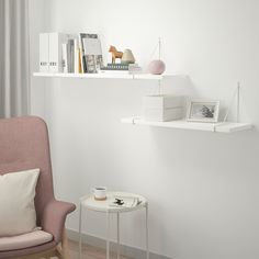 a chair and table in a room with books on the shelves above them, along with other items