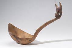 a wooden spoon shaped like an antelope with long horns and sharp beaks