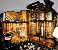 an open suitcase filled with lots of bottles and glasses on top of a marble counter