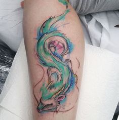 a colorful dragon tattoo on the left arm and leg, with watercolor splashes