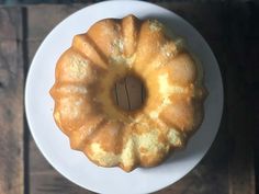 a bundt cake sitting on top of a white plate next to a wooden table