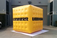 an inflatable cube sitting on top of a parking lot next to a building