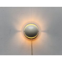 a light that is on the side of a wall with a circular object attached to it