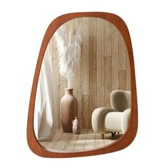 a mirror that is on the wall with a chair and vase in front of it