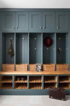 a wooden bench with baskets on it in front of some blue cupboards and shelves