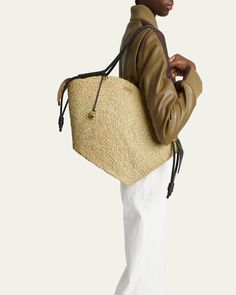 Loewe "Paseo" basket tote bag in raffia and leather     Rolled shoulder straps with Anagram pebble accent     Zip top closure     Interior, one slip pocket     Approx. 12.5"H x 22.6"W x 5.5"D    Made in Spain Designer Straw Tote Bag With Braided Handles, Luxury Leather Basket Bucket Bag, Designer Straw Bucket Bag With Braided Handles, Designer Natural Bucket Bag With Braided Handles, Designer Natural Straw Tote Bag, Designer Double Handle Straw Bag For Everyday, Designer Natural Straw Bag For Daily Use, Designer Bucket Bag With Leather Handles In Natural, Designer Straw Shoulder Bag With Leather Handles