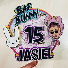 someone holding up a sticker with the number 15 in front of them and an image of a bunny on it