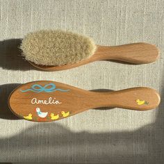 two wooden brushes sitting next to each other on top of a cloth covered tablecloth