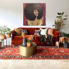 a living room with an orange couch, rug and potted plants on the floor