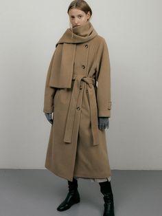 This is a long coat with a muffler design that allows for a variety of styles and is comfortable to wear even in the middle of winter. It has back pleats to create a three-dimensional semi-A-line silhouette, and the round neck design and double fastening make it a wearable design. Sleeve cutouts are rounded and curved for comfortable movement and a three-dimensional silhouette.There is a button on the belt to prevent it from slipping off.Use of wool material with a classic yet luxurious tex Winter Scarf For Cold Weather, Fall Beige Outerwear With Scarf, Fall Wool Outerwear With Scarf, Muffler Design, Wearables Design, Vibe Check, Round Neck Design, W Concept, Long Coat