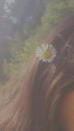 a close up of a woman's hair with a flower in the middle of it