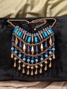 "This Stella & Dot Malta Bib Statement Necklace features blues inspired by the Indian Ocean. Hand assembled with genuine turquoise stones, lapis blue beads, and accented with vintage gold plate onto a brass chain. Looks great both long or short (can be adjusted from 17\" - 21\") and either over fresh white or any other shade of bright color. Previously owned but in perfect condition. Originally priced $118." Blue Beaded Brass Necklaces, Blue Dangle Beaded Costume Jewelry Necklace, Bohemian Metal Necklace With Gold Beads, Bohemian Metal Necklaces With Gold Beads, Bohemian Gold Turquoise Necklace With Polished Beads, Blue Beaded Necklace With Dangling Beads For Costume Jewelry, Blue Beaded Chain Metal Necklace, Blue Beaded Necklace With Dangling Beads, Gold Bohemian Turquoise Necklace With Polished Beads