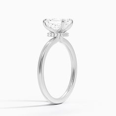 an oval shaped diamond engagement ring on a white background