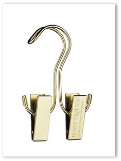 a pair of gold metal hooks on a white background