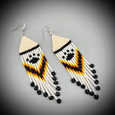 two pairs of beaded earrings with black and white beads hanging from the end of each pair