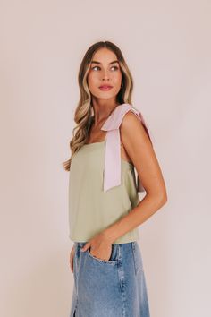 Get ready to hop into style with our Lily-Pad Lovin' Top! Crafted with silky satin material and adorned with playful bow straps. Available in a refreshing green hue with playful pink straps. Upgrade your wardrobe with this fun addition! Details Bow straps Sily/satin material Sizing Approximate measurements: SIZE LENGTH BUST Small 21" 36" Medium 22" 38" Large 23" 40" Fabric has no stretchModel is 5’8 wearing small Material 97% Polyester 3% SpandexHand wash coldHang to dry Spring Party Tops With Ribbon, Chic Spring Tops With Ribbon, Feminine Tops With Ribbon For Spring, Feminine Ribbon Tops For Spring, Green Satin Summer Tops, Green Satin Top For Summer, Chic Spring Tops With Bow Straps, Green Satin Tops For Summer, Pink Tops With Ribbon For Spring