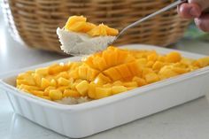 a spoon with some food in it on top of a white dish and a basket