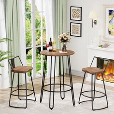 a small table with two stools in front of a fireplace