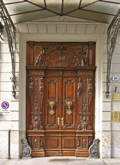 an ornate wooden door on the side of a building