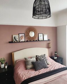 a bed room with a neatly made bed and some pictures on the wall above it