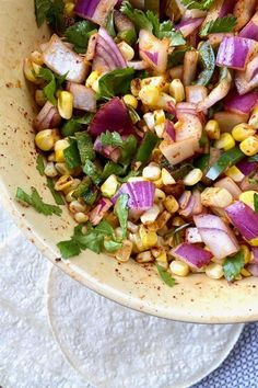 a bowl filled with corn, onions and cilantro