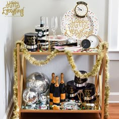 a bar cart filled with champagne bottles and confetti for new year's eve