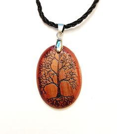 "This pendant is made from gorgeous red cedar wood. The Tree Of Life graphic is seared into the surface of the wood using a pyrography (wood burning) pen. The finish consists of multiple coats of glossy Spar Urethane. Designs for use on boats, this finish is far more resistant to UV and water than conventional polyurethane. Includes an 18\" nylon cord and all necessary hardware." Handmade Mahogany Jewelry Gift, Engraved Natural Wood Necklace As Gift, Bohemian Natural Wood Jewelry Gift, Bohemian Natural Wood Necklaces As Gift, Bohemian Natural Wood Jewelry As Gift, Mahogany Handmade Jewelry For Gift, Handmade Mahogany Jewelry For Gift, Unique Mahogany Jewelry For Gift, Bohemian Natural Wood Necklace As Gift