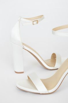 Lulus Exclusive! No one does it quite like the Lulus Taylor Ivory Satin Ankle Strap Heels! Whether you choose to dress them up or down, these sleek, satin single sole heels will stun with their slender toe strap, and adjustable ankle strap (with a gold buckle). 4" wrapped block heel. Cushioned insole. Nonskid rubber sole. Man made materials. Imported. Lulus | Taylor Ivory Satin Ankle Strap Heels | Size 8. Satin Heels With Padded Heel And Round Toe, Chic Satin Heels With Round Toe, White Satin Ankle Strap Heels, White Satin Heels For Summer, Sleek White Heels With Wrapped Heel, Satin Heels With Padded Open Heel, Chic Satin Heels With Block Heel, Satin High Heels With Padded Heel, Satin Open Heels With Padded Heel