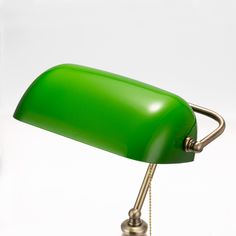 a green desk lamp sitting on top of a white table