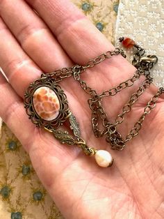 "A vintage Carnelian and filigree  earring no longer has the pin on the back so it has been repurposed into a wonderful pendant necklace. It is antique brass with a 3/4 x 1/2\" oval, faceted Carnelian cabochon.  dangling at the bottom is a lovely Freshwater Pearl.  The 18 1/2\" antique brass, oval link chain also has a 1\" extender chain and closes at the neck with a lobster clasp and small Carnelian dangle This unique, repurposed necklace has a wonderful Victorian feel ♥ Buy Unique. Buy Quality Vintage Oval Necklaces With Intricate Design, Cameo Carnelian Jewelry Gift, Carnelian Cameo Jewelry Gift, Ornate Copper Jewelry With Antique Finish, Bohemian Filigree Jewelry Vintage Collection, Victorian Copper Jewelry With Antique Finish, Bohemian Cameo Jewelry For Gifts, Bohemian Cameo Jewelry Gift, Ornate Antique Finish Copper Jewelry