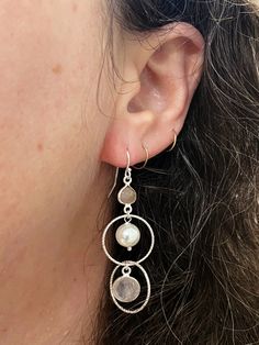 Indulge in the soft, romantic beauty of the Embrace Collection. Handcrafted to perfection, these dangle earrings are a charming addition to any wardrobe. Textured silver ringlets encircle rose quartz and freshwater pearl beads. Complete the set with matching bracelet! Sterling Silver ear wires & details (Lead & Nickel Free) Just over 2" long Each design created is individually crafted in a mountain studio in Floyd, Virginia by Anne Vaughan Original Jewelry Feminine Sterling Silver Dangle Jewelry, Elegant Nickel-free Rose Quartz Earrings, Feminine Round Pearl Drop Jewelry, Silver Dangle Earrings, Feminine Style, Feminine Silver Dangle Earrings, Silver Dangle Earrings Feminine Style, Silver Pearl Drop Feminine Jewelry, Feminine Sterling Silver Pearl Drop Jewelry, Feminine Silver Jewelry With Pearl Drop