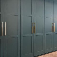 an image of a kitchen setting with green cabinets and gold handles on the door knobs