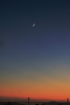 the moon is seen in the sky over san francisco bay bridge at sunset, california