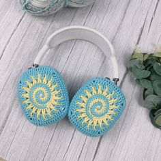 two crocheted headphones sitting on top of a wooden table