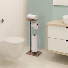 a white toilet sitting next to a sink in a bathroom on top of a wooden counter