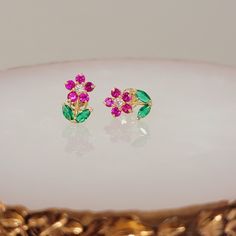 14K Gold Flower Earrings, Ruby and Diamond Flower Studs, Dainty Earrings, Gift for Mom Solid 14K Yellow Gold Flower Earrings available in Ruby Emerald Clear CZ or Ruby Emerald and mined Diamond please specify when placing your order! Height: 10.6mm Width: 7.1mm Thickness: 1.6mm Stone material: green, ruby & clear cubic zirconia Center stone size: 2mm Stone shape: round & marquise cut Center stone carat weight: .03 CT Total number of CZ stones: 16 Stone setting: prong setting Metal: Solid 14K Yel Fine Jewelry Flower Earrings For Gift, Fine Jewelry Flower Cluster Earrings For Gifts, Pink Flower Earrings For Mother's Day Anniversary, Flower Shaped Fine Jewelry Earrings For Anniversary, Fine Jewelry Flower Earrings For Anniversary, Gold Flower Earrings, Ruby Emerald, Diamond Flower, Gold Flower