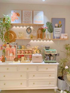 a white dresser topped with lots of vases and plants